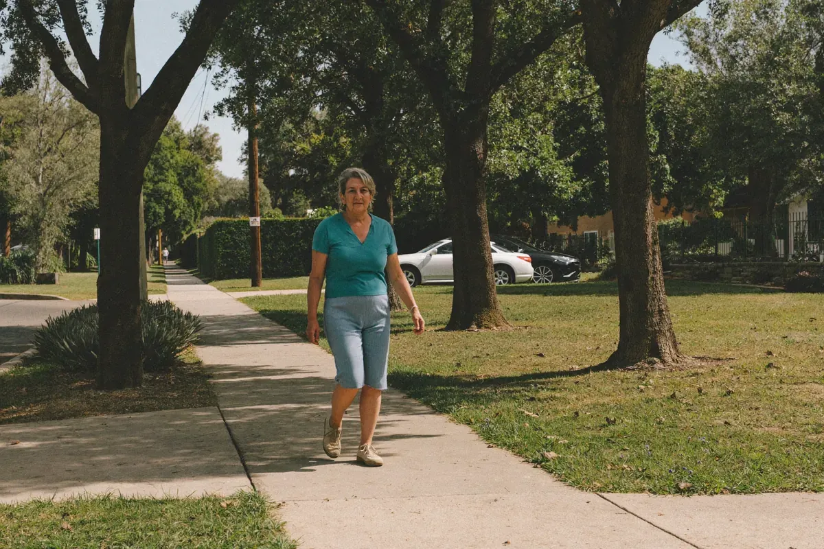 Woman walking at an easy pace on a flat, shaded sidewalk