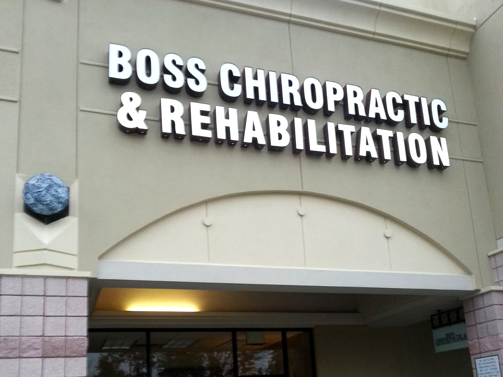 Boss Chiropractic and Rehabilitation storefront sign above the office entrance in The Woodlands
